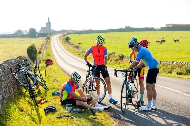 Attent des cyclistes du groupe pendant la réparation d'un pneu